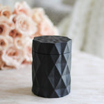 matte black candle jar next to pink rose bouquet on coffee table decor