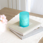 light teal color glass candle jar on home decor coffee table books on kitchen table