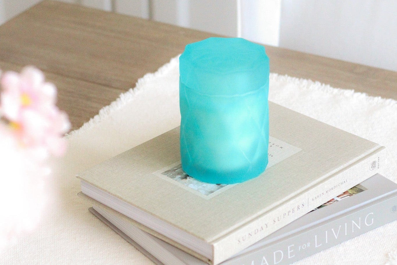 light teal color glass candle jar on home decor coffee table books on kitchen table
