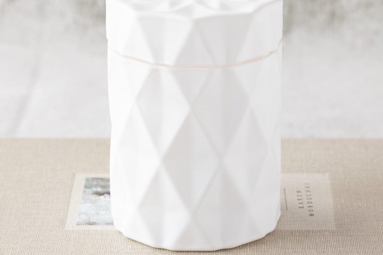 candle in a matte white glass jar with lid and diamond glass etching design